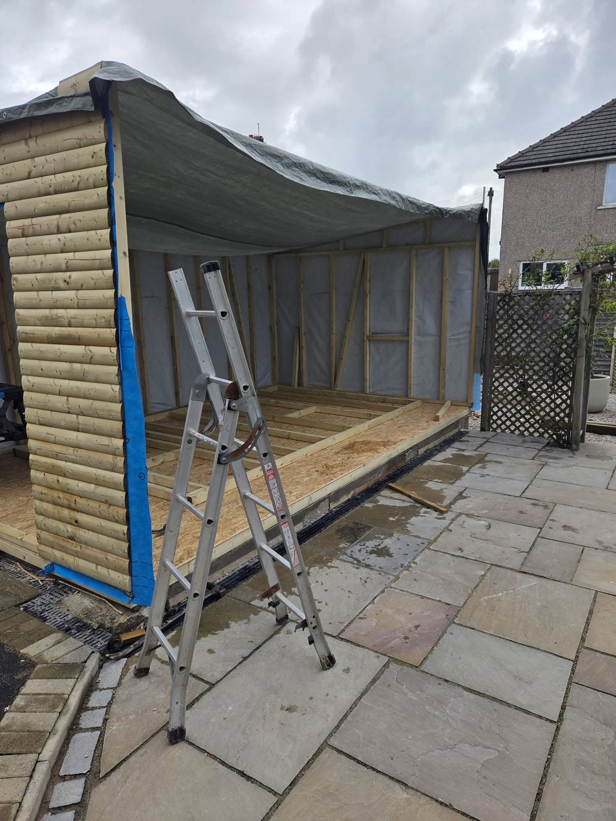 Timber frame and roof going up, ladder against the frame